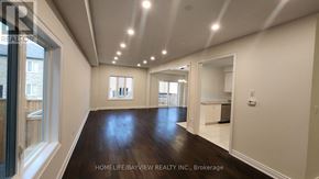 Innisfil (Lefroy) apartment for rent - A spacious room with wooden floors and white walls, part of a real estate brokerage.