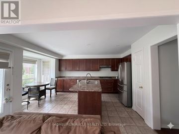 Brampton (Credit Valley) apartment for rent - A kitchen with brown cabinets and a marble island.