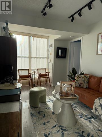 Mississauga (Mississauga Valleys) condo for rent - A living room with a brown couch and a white ottoman.
