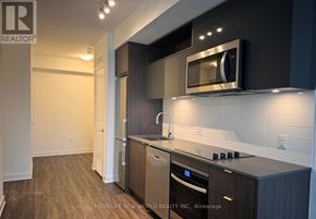Toronto (Church-Yonge Corridor) condo for rent - A modern kitchen with dark wood cabinets and stainless steel appliances.