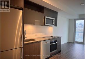 Toronto (Church-Yonge Corridor) condo for rent - A modern kitchen with a stainless steel refrigerator and microwave above the stove.