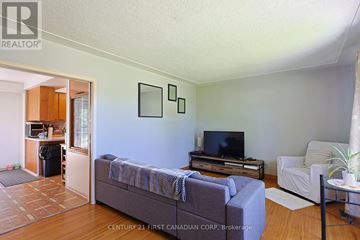 London South (South J) apartment for rent - A living room with a grey couch and a television on a wooden stand.