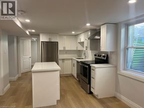 Kitchener apartment for rent - A kitchen with white cabinets and a refrigerator.