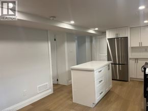 Kitchener apartment for rent - A white kitchen with a refrigerator and a white island.