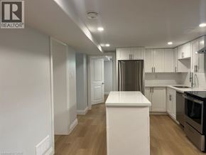 Kitchener apartment for rent - A kitchen with white cabinets and a wooden floor.