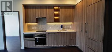 Toronto (Bayview Village) condo for rent - A kitchen with wooden cabinets and a marble countertop.