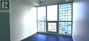 Toronto (Bayview Village) condo for rent - A room with a large window showing a view of a building outside.