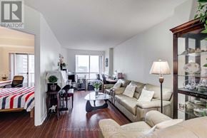 Toronto (Church-Yonge Corridor) condo for rent - A well-lit, spacious living room with a sofa, a coffee table, and a bed with a striped comforter.