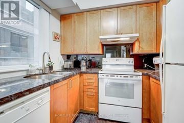 Toronto (Church-Yonge Corridor) condo for rent - A kitchen with wooden cabinets and white appliances.