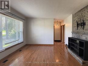 Caledon (Caledon East) apartment for rent - A room with wooden floors and a fireplace.