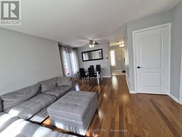Milton (Be Beaty) apartment for rent - A living room with a grey couch and wooden floors.