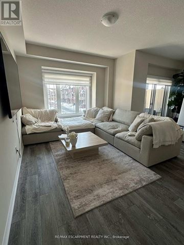 Hamilton (Stoney Creek Mountain) townhouse for rent - A living room with a grey couch and a coffee table.