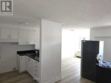 Aurora (Hills Of St Andrew) multi-family for rent - A kitchen with white cabinets and black countertops.