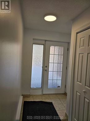 Aurora (Hills Of St Andrew) multi-family for rent - A hallway with a door and a mat on the floor.