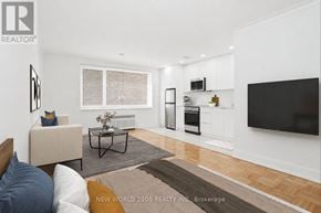 Toronto (Rosedale-Moore Park) condo for rent - A living room with a white couch and a black coffee table.