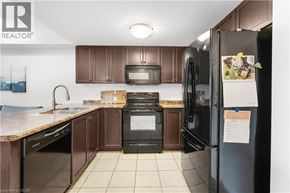 Guelph condo for rent - A kitchen with brown cabinets and a black fridge.