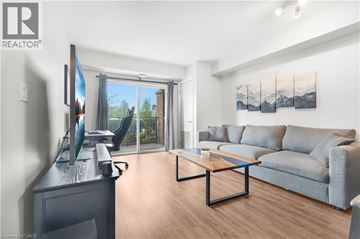 Guelph condo for rent - A living room with a grey couch and a wooden coffee table.