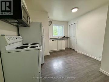 Oshawa (Vanier) apartment for rent - A small, clean kitchen with a white stove and cabinets.