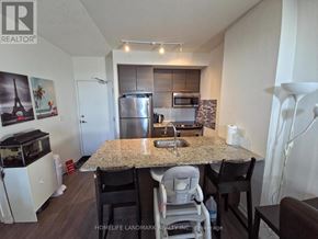 Toronto (Henry Farm) condo for rent - A kitchen with a granite countertop and a refrigerator.