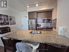 Toronto (Henry Farm) condo for rent - A kitchen with granite countertops and a refrigerator.