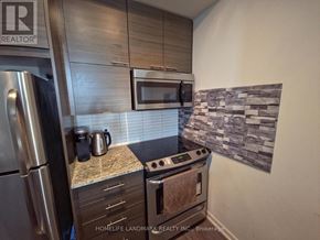 Toronto (Henry Farm) condo for rent - A kitchen with a stove top oven and a microwave above it.