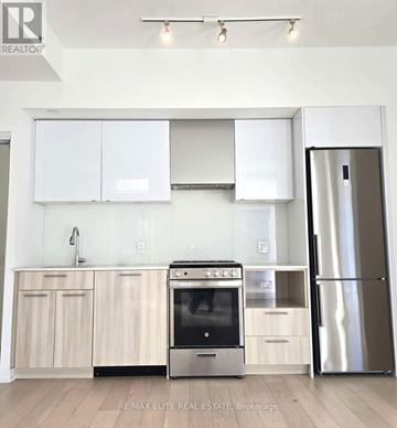 Toronto (Church-Yonge Corridor) condo for rent - A modern kitchen with white cabinets and stainless steel appliances.