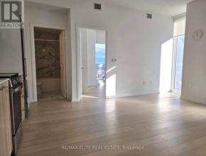 Toronto (Church-Yonge Corridor) condo for rent - A spacious living room with a kitchen area in the background.
