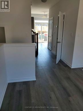 Hamilton (Stoney Creek) townhouse for rent - A hallway with wood floors and white walls.