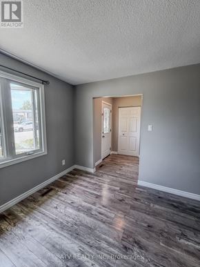 Woodstock (Woodstock - South) apartment for rent - A room with grey walls and wooden flooring with a doorway leading to another room.