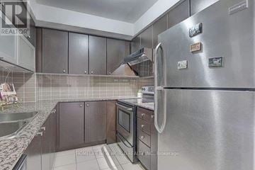 Toronto (Henry Farm) condo for rent - A modern kitchen with a stainless steel refrigerator and wooden cabinets.