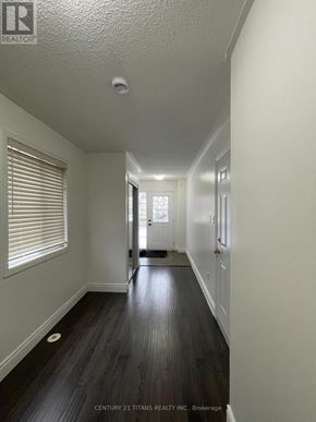 Toronto (Clairlea-Birchmount) townhouse for rent - A hallway with wood floors and white walls.