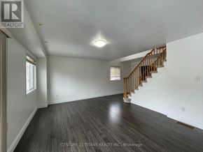 Toronto (Clairlea-Birchmount) townhouse for rent - A spacious room with wooden floors and a staircase.