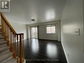 Toronto (Clairlea-Birchmount) townhouse for rent - A spacious room with a staircase leading to the upper floor.