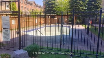 Vaughan (Crestwood-Springfarm-Yorkhill) condo for rent - A pool surrounded by a black fence with a sign that says TFN Realty INC., Brokerage.