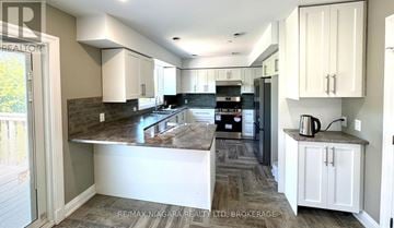 St. Catharines (Burleigh Hill) apartment for rent - A kitchen with a marble countertop and white cabinets.