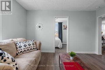 London East (East K) multi-family for rent - A living room with a couch and a clock on the wall.