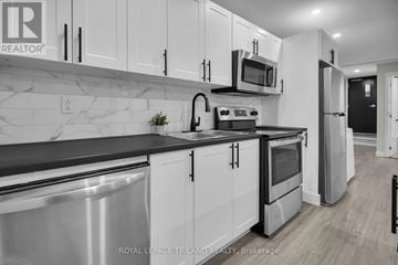 London South (South F) multi-family for rent - A kitchen with white cabinets and black countertops.