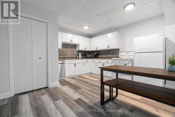 London East (East K) multi-family for rent - A kitchen with white cabinets and a wooden bench.