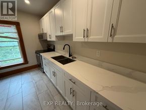 Orangeville duplex for rent - A kitchen with white cabinets and a marble countertop.
