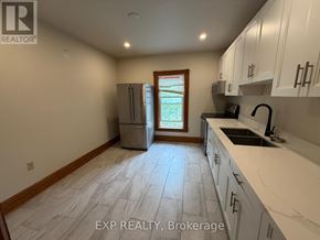 Orangeville duplex for rent - A kitchen with white cabinets and a tile floor.