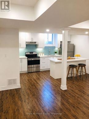 Toronto (Malvern) apartment for rent - A kitchen with white cabinets and a wooden floor.