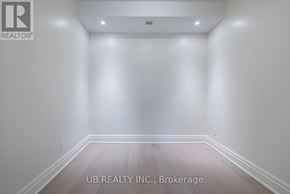 Ottawa condo for rent - A room with white walls and wooden flooring, with the text "UB REALTY INC., Brokerage" on the bottom.