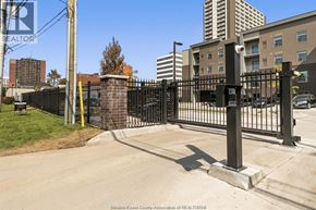 Windsor condo for rent - A black metal fence with a gate blocks the entrance to a driveway.