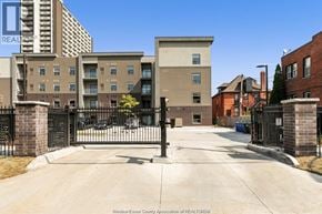 Windsor condo for rent - A gated entrance to a residential area with apartment buildings.
