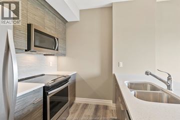 Windsor condo for rent - A modern kitchen with a stainless steel oven and microwave.