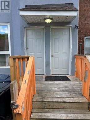 Toronto (East End-Danforth) apartment for rent - A grey house with a white door and a wooden staircase leading to it.