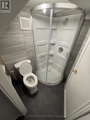 Toronto (East End-Danforth) apartment for rent - A white toilet is next to a walk-in shower in a bathroom.
