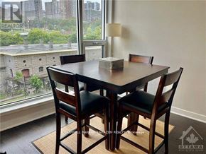 Ottawa condo for rent - A dining room with a table and chairs in front of a window overlooking a cityscape.