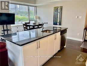 Ottawa condo for rent - A kitchen with white cabinets and a black countertop.