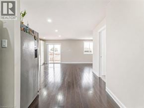 Hamilton apartment for rent - A sparsely furnished room with a refrigerator on the left and a doorway leading to another room.